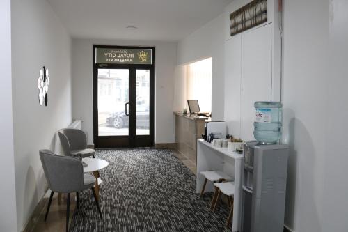 a waiting room with a desk and chairs and a door at Royal City Apartments in Jajce