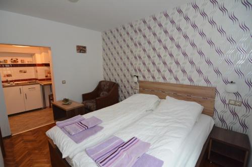 a bedroom with a bed with purple towels on it at Apartament Supercentral Sibiu in Sibiu