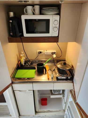 cocina pequeña con fogones y microondas en Infinit Point Apartment en Buenos Aires
