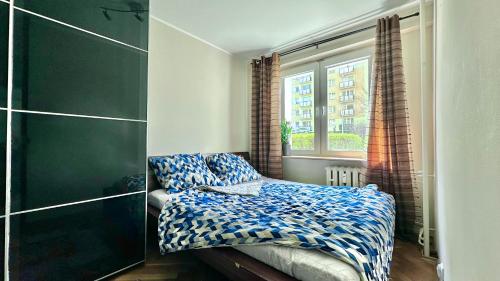 Habitación pequeña con cama y ventana en Uroczy apartament - Sopot en Sopot
