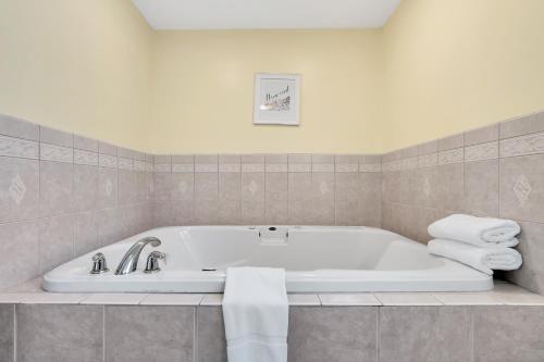a white bath tub in a bathroom with towels at Abellona Inn & Suites in Old Orchard Beach