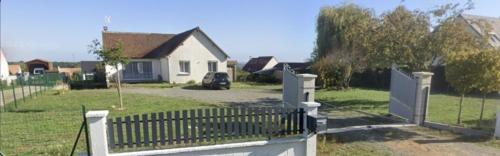 uma cerca branca num quintal com uma casa em Chambre à 25 min du circuit des 24h . em La Bazoge