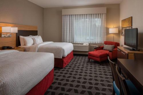 um quarto de hotel com duas camas e uma televisão de ecrã plano em TownePlace by Marriott Suites Clarksville em Clarksville