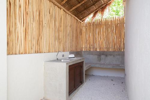 a bathroom with a sink and a wooden bench at UTSKIN By ZENDA - Luxury Villas & Private Pools in Tulum