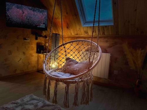 een hangende stoel met een kussen in een kamer bij Villa Spacieuse SPA Sauna Billiard Netflix in Straatsburg