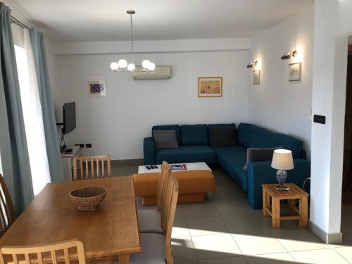 a living room with a blue couch and a table at Apartments Trlika in Kampor