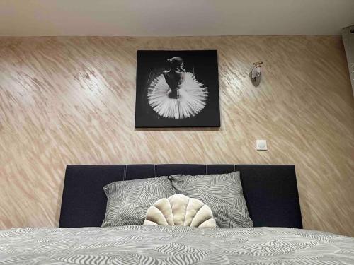 a bedroom with a bed with a picture on the wall at Villa Spacieuse SPA Sauna Billiard Netflix in Strasbourg
