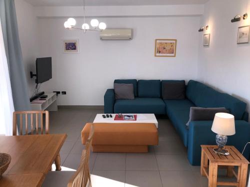 a living room with a blue couch and a table at Apartments Trlika in Kampor