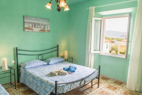 a bedroom with a bed with blue walls and a window at Appartamenti Celestina Portoferraio in Portoferraio