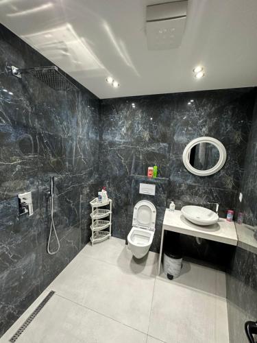 a bathroom with a toilet and a sink and a mirror at CozyStayApartments by Flow in Tirana