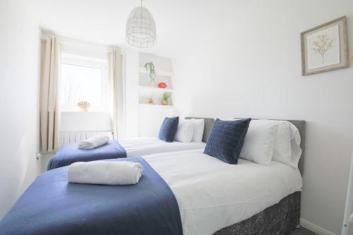 1 dormitorio con 2 camas y almohadas azules en StayRight 2Bed Apartment Overlooking Water with Free parking and 2 Bathrooms, en Cardiff