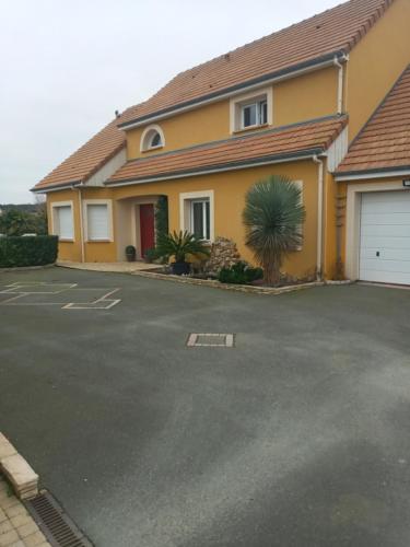 a house with a parking lot in front of it at 24 heures du Mans Chambre d'hôte avec piscine in La Suze-sur-Sarthe