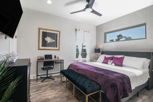 a bedroom with a large bed with a purple blanket at Luxury Family home near Casinos with King Bed, steps away from the Beach, Game Room, and Free Parking in Gulfport