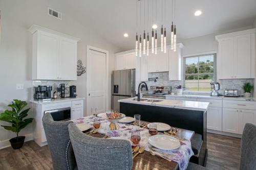 a kitchen with a table with chairs and a sink at Steps Away from Cruisin' the Coast , Gulfport 2BR, Game Room, and Free Parking in Gulfport