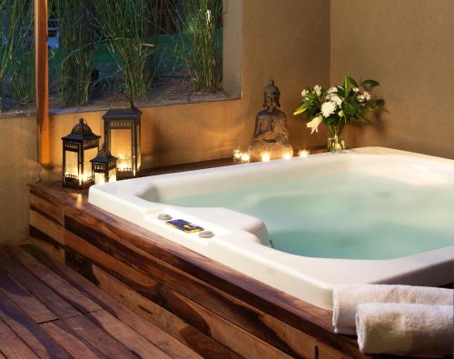 a bath tub in a bathroom with candles and lights at Plenilunio Mar de las Pampas in Mar de las Pampas