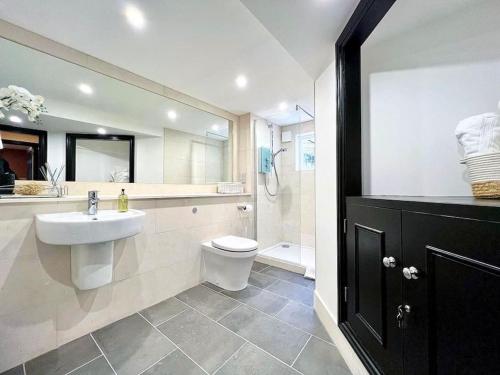 y baño con lavabo, aseo y ducha. en Fabulous Large apartment in great location, en Bath