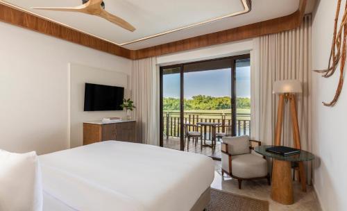 a hotel room with a bed and a balcony at Fairmont Mayakoba in Playa del Carmen