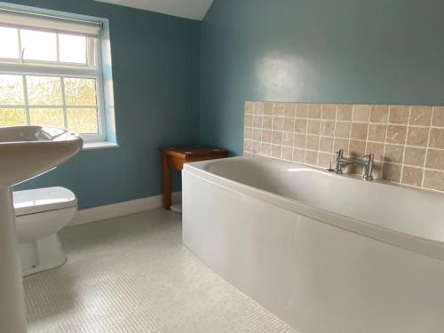 a bathroom with a tub and a toilet and a sink at Fryers Cottage, Seamer, 3 Bed cottage sleeps 5 people in Seamer