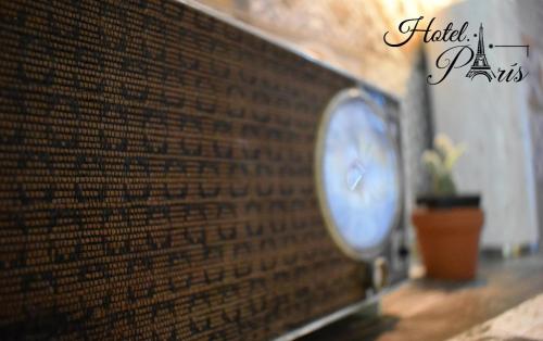 un muro di mattoni con orologio e pianta in vaso di hotel marsella a Sonsonate