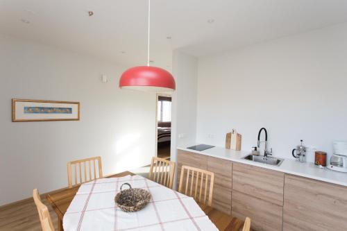 a kitchen and dining room with a table and a red lamp at Glaumbær III in Varmahlid
