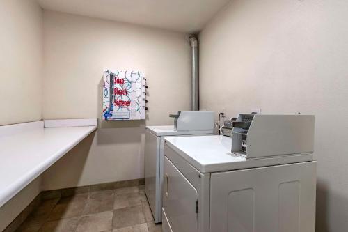 Habitación blanca con 2 máquinas y barra. en Sleep Inn & Suites Pleasant Hill - Des Moines, en Pleasant Hill