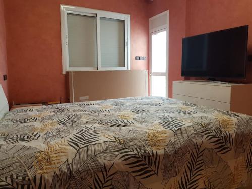 1 dormitorio con 1 cama y TV de pantalla plana en Appartement lala yasmine en Fez