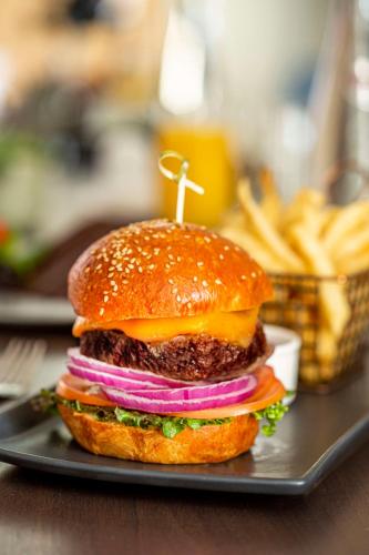 a hamburger with onions and cheese on a plate at The Yorkville Royal Sonesta Hotel Toronto in Toronto