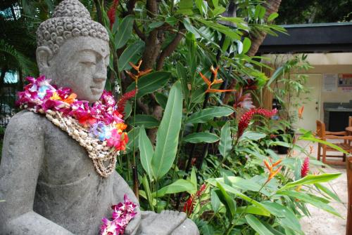 a statue of a buddha wearing a flower necklace at Castle Bamboo Waikīkī Hotel in Honolulu