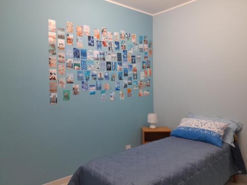 a bedroom with a bed and a wall covered in pictures at Fuori dal Borgo.... in Vitorchiano