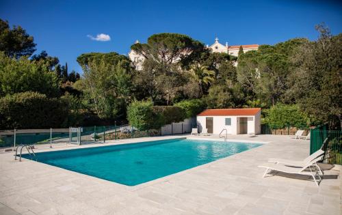 einen Pool mit einem Stuhl und ein Haus in der Unterkunft Suite Tropez, Résidence de prestige in La Croix-Valmer