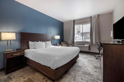 a bedroom with a large bed and a large window at Clarion Inn Kingman I-40 Route 66 in Kingman