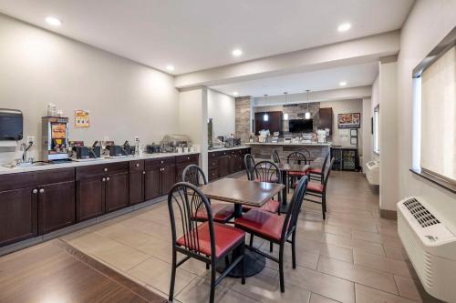 a dining room with a table and chairs and a kitchen at Clarion Inn Kingman I-40 Route 66 in Kingman