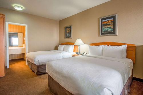 a hotel room with two beds and a window at Clarion Suites St George - Convention Center Area in St. George