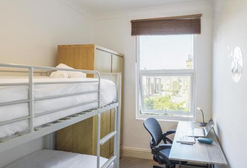 a bedroom with bunk beds and a desk and a bed at The Brixton Apartment in London