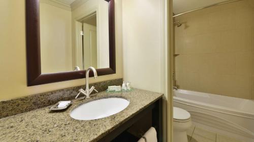 a bathroom with a sink and a toilet and a mirror at Prestige Beach House, WorldHotels Crafted in Kelowna