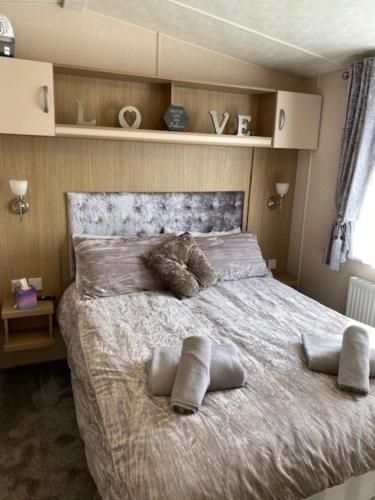 - une chambre avec un grand lit et des oreillers dans l'établissement Spacious Holiday Home - Romney Sands, à Littlestone-on-Sea