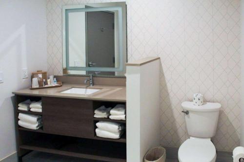 ein Badezimmer mit einem Waschbecken, einem WC und einem Spiegel in der Unterkunft Comfort Suites in Richmond