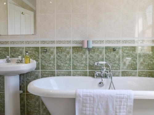 a bathroom with a tub and a sink and a bath tub at Meadowview in Honington