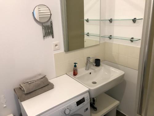 Baño blanco con lavabo y espejo en Appartement T2 sur le lac d'Hossegor, en Soorts-Hossegor