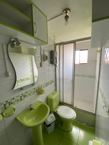 ein Badezimmer mit grünem WC und Waschbecken in der Unterkunft Apart La Posada in Tacna