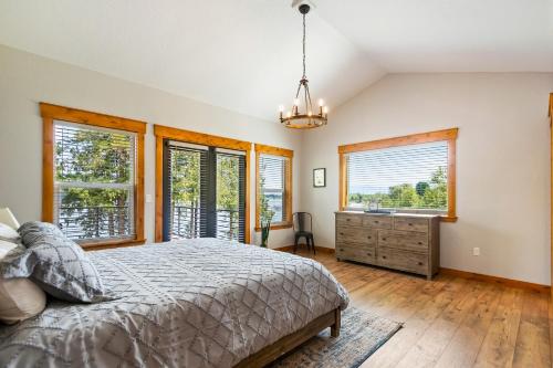 a bedroom with a bed and windows and a dresser at Willow Bay in Priest River