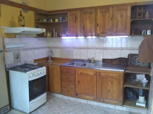 a kitchen with wooden cabinets and a stove top oven at Laura in Rosario