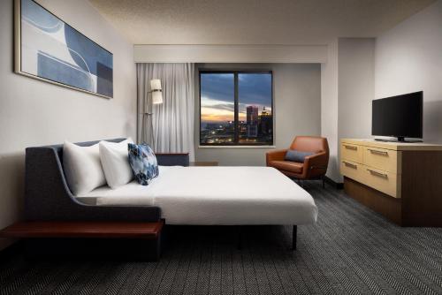 ein Hotelzimmer mit einem Bett, einem Stuhl und einem TV in der Unterkunft Courtyard by Marriott Atlantic City Beach Block in Atlantic City