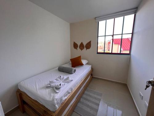 a bedroom with a bed with a flower on it at Apto Nuevo, Tranquilo a 5 min Plaza Principal in Guatapé