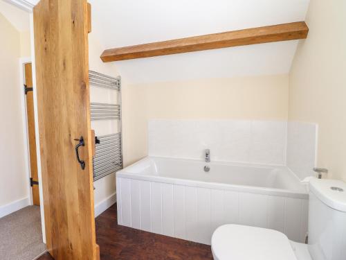 a bathroom with a white tub and a toilet at Beudy Bach Barn in Llanuwchllyn