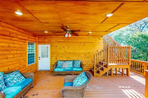 a cabin with a porch with chairs and a ceiling fan at Ark Ranch in Princeton