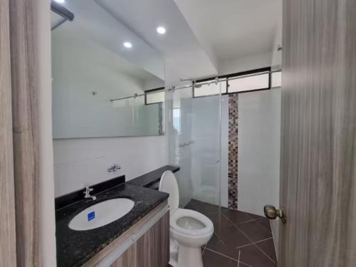uma casa de banho com um WC branco e um lavatório. em Apto Botero 1308 - WAIWA HOST em Floridablanca