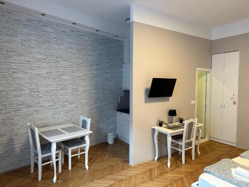 sala de estar con mesa, sillas y pared en Nice 5 Apartments, en Sarajevo