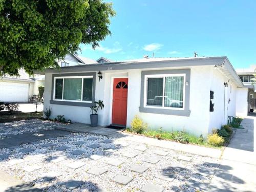 a white house with a red door at Cozy house near Disney, Knott’s & Beach!! in Fullerton