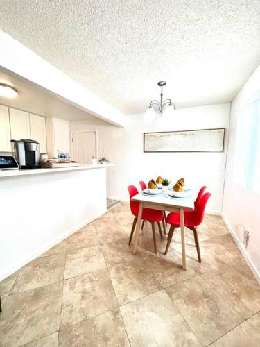 a kitchen with a table and two red chairs at Cozy house near Disney, Knott’s & Beach!! in Fullerton